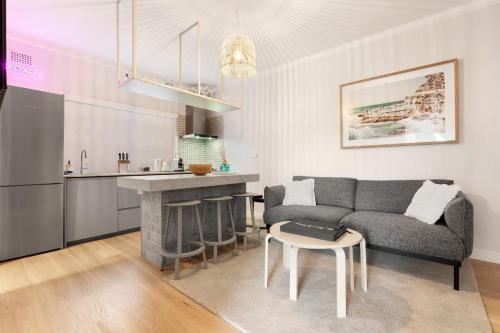 a living room with a couch and a kitchen at Sunlit 2BR Coastal Charm Bondi Beach Beach View in Sydney