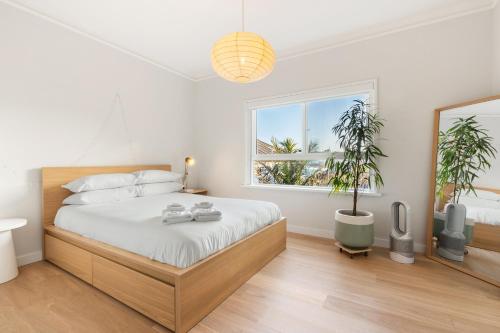Un dormitorio con una cama grande y una ventana en Sunlit 2BR Coastal Charm Bondi Beach Beach View, en Sídney