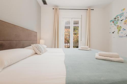 Un dormitorio blanco con una cama grande y una ventana en Modern Sea & Lake View Penthouse with Private Jacuzzi - 8 min to Puente Romano, en Istán