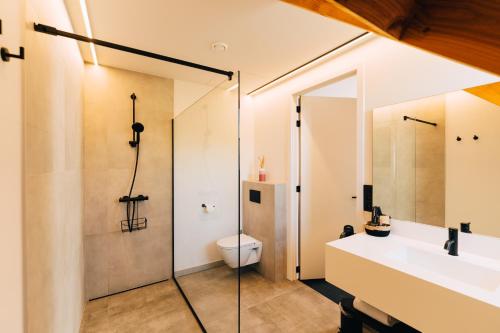 a bathroom with a shower and a sink and a toilet at Factory Hotel in Beveren