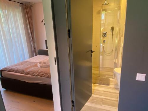 a bathroom with a shower and a bedroom with a bed at Pervalka Apartaments With Large Terrace in Pervalka