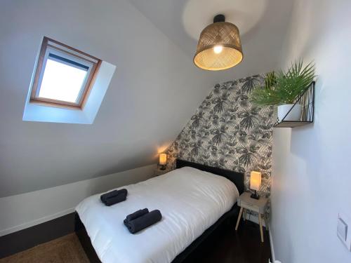 a bedroom with a bed with two black bags on it at Sous les tropiques d’Ablis in Ablis