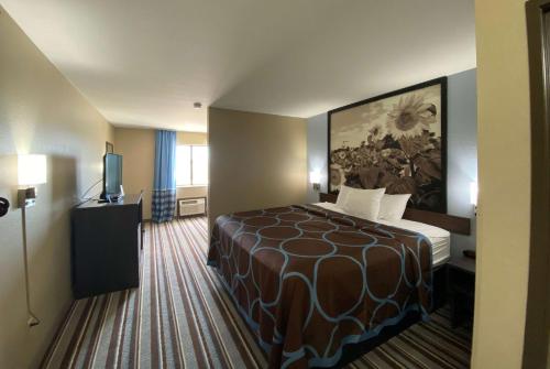 una habitación de hotel con una cama y un cuadro en la pared en Super 8 by Wyndham Independence, en Independence