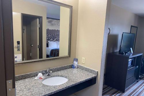 een badkamer met een wastafel en een grote spiegel bij Super 8 by Wyndham Independence in Independence