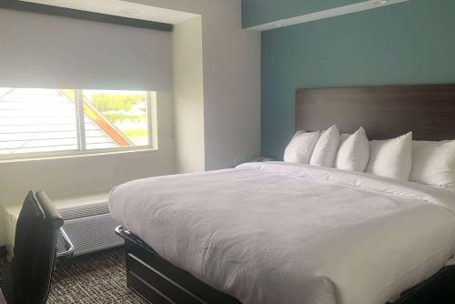 een groot bed in een hotelkamer met een raam bij Baymont by Wyndham Boardman in Boardman