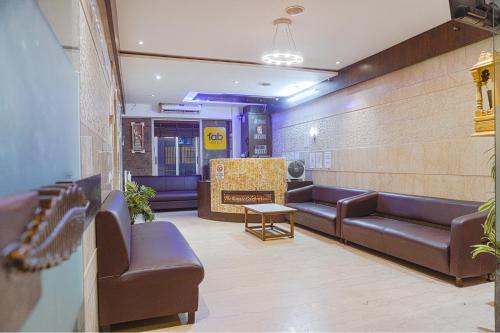 a waiting room with leather couches and a fireplace at FabHotel Royale Celebrations in Surat