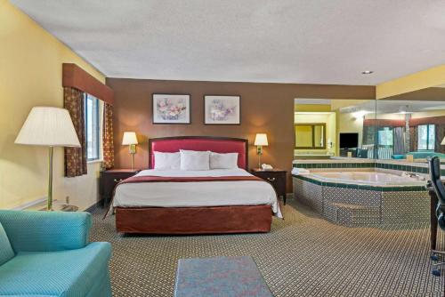 ein Hotelzimmer mit einem Bett und einer Badewanne in der Unterkunft Baymont by Wyndham Washington Court House in Jeffersonville