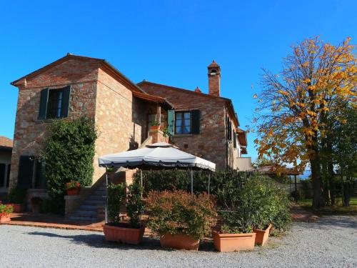 フォイアーノ・デッラ・キアーナにあるModern Holiday Home in Foiano della Chiana with Poolの傘を持つ家