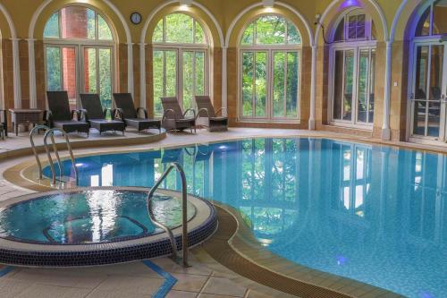 una grande piscina in un edificio con una grande piscina di Moor Hall Hotel, BW Premier Collection a Sutton Coldfield