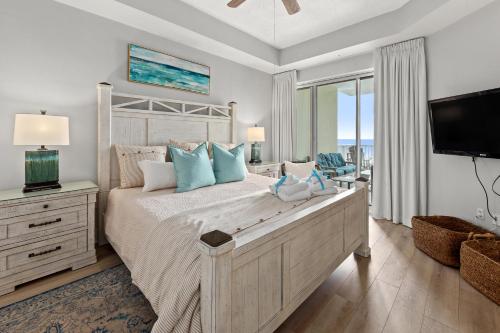 a bedroom with a large bed and a television at Crescent at Miramar 406 - Sheer Bliss in Destin