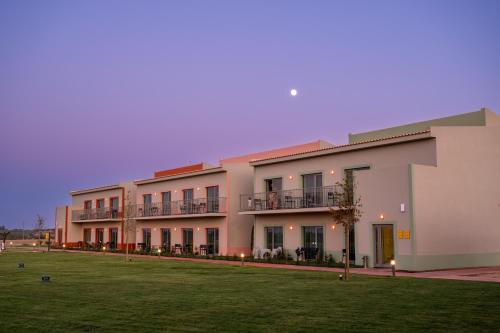 un grand bâtiment avec une pelouse devant lui dans l'établissement Vila Gale Nep Kids, à Beja