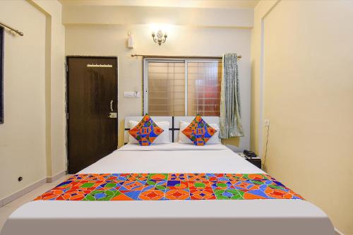 a bedroom with a king sized bed with a colorful quilt at FabExpress 4 Star Executive - Nr World Trade Center in Pune