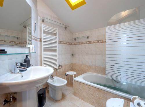 ein Badezimmer mit einem Waschbecken, einer Badewanne und einem WC in der Unterkunft Babyaccommodation Stay in Family III in Pietra Ligure