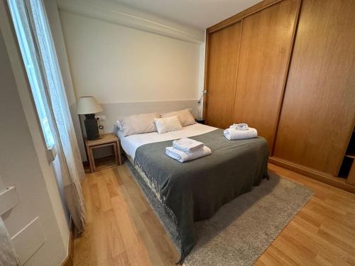 een slaapkamer met een bed met twee handdoeken erop bij Oktheway Santander 2 in A Coruña