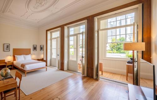 a bedroom with a bed and a room with windows at Casa do Arquiteto - Townhouse - Architect's House in Porto