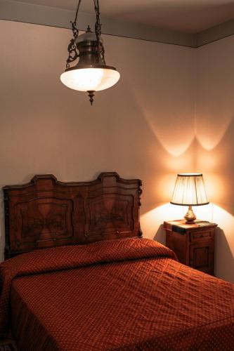 a bedroom with a bed with a red comforter and a lamp at Hotel Liberty in Spresiano