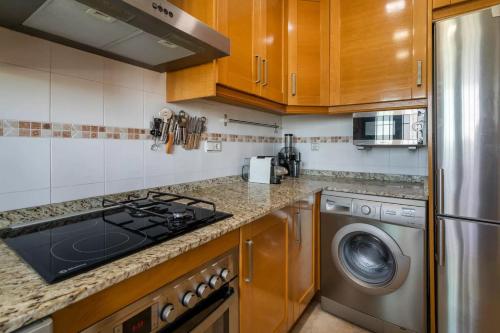a kitchen with a stove top oven next to a dishwasher at luxury resort vistas al mar in Arenales del Sol