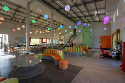 a room with chairs and tables and a climbing wall at Vila Gale Nep Kids in Beja