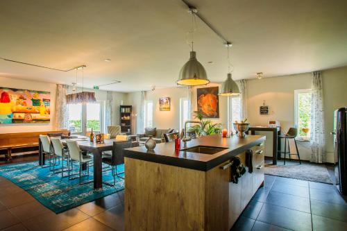 a kitchen and living room with a table and chairs at B&B/Boertel de Meander in Oirschot