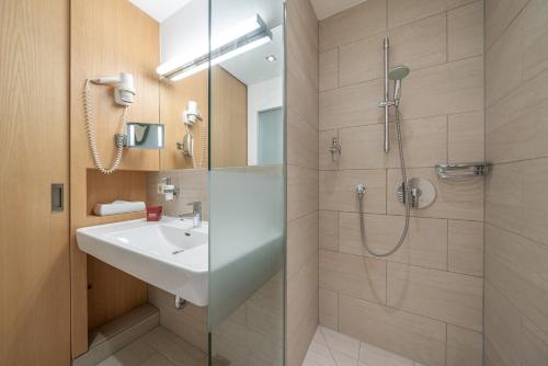 a bathroom with a sink and a shower at Hotel Salzburger Hof Leogang in Leogang