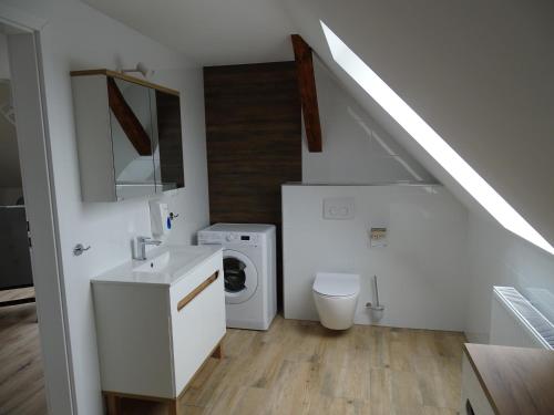 a bathroom with a sink and a washing machine at Mieszkania pracowniczo-turystyczne in Żelazna