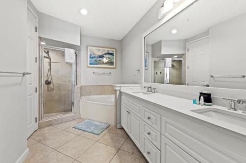 a bathroom with two sinks and a tub and a shower at Crescent at Miramar 406 - Sheer Bliss in Destin