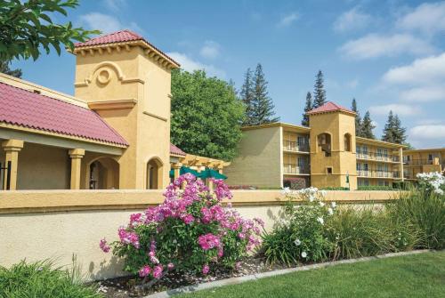 a retaining wall with flowers in front of a building at Howard Johnson by Wyndham Sacramento Downtown in Sacramento