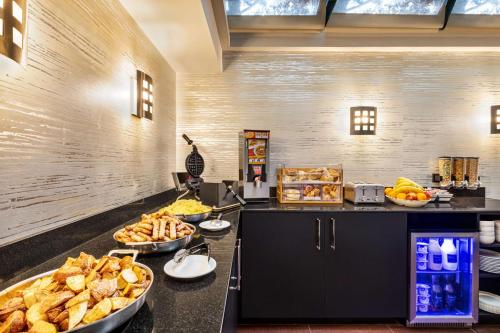 Un buffet con muchos tipos diferentes de comida en un mostrador. en Inn at Great Neck, en Great Neck