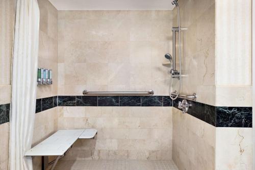 a shower with a bench in a bathroom at Inn at Great Neck in Great Neck