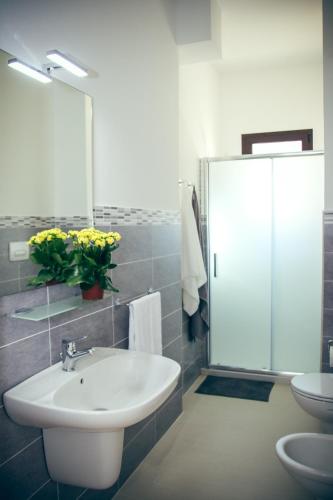 a bathroom with a sink and a toilet and a mirror at Il Sorriso B&B in Ugento