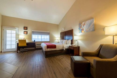 Comfort Inn & Suites Alamosa في ألاموسا: غرفه فندقيه بسرير ومكتب وكرسي