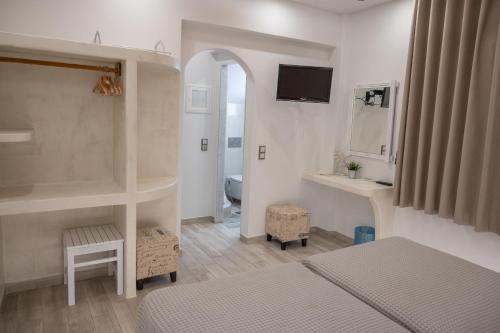 een slaapkamer met een bed, een wastafel en een spiegel bij Katerina Roza Studios in Naxos Chora