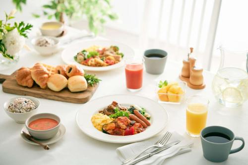 stół z talerzami produktów śniadaniowych i napojów w obiekcie Comfort Hotel Central International Airport w mieście Tokoname