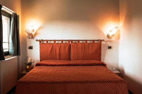 a bedroom with a bed with a red bedspread at Hotel Liberty in Spresiano