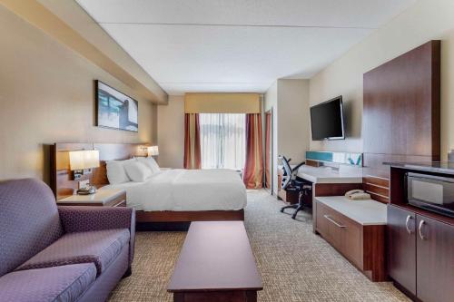 a hotel room with a bed and a living room at Comfort Suites East in Knoxville