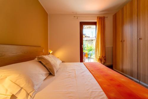 a bedroom with a large white bed and a window at Casa Caravina by Wonderful Italy in Civenna