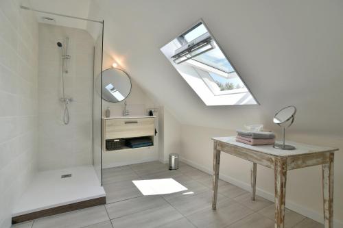 a bathroom with a shower and a table with a mirror at Maison Grand Large - A 800 m de la plage in Saint-Cast-le-Guildo
