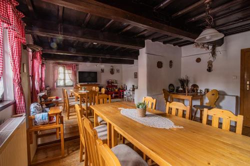 une salle à manger avec une grande table et des chaises en bois dans l'établissement Penzion Sněžná Volary, à Volary