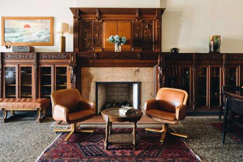 a living room with two chairs and a fireplace at Chicago Athletic Association, part of Hyatt in Chicago
