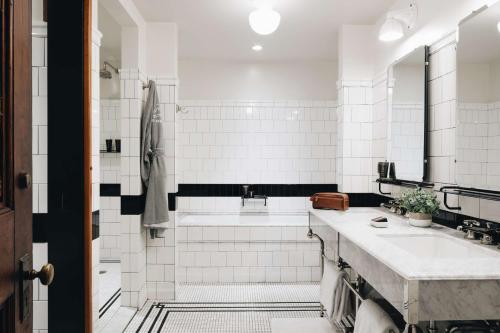 a white bathroom with a sink and a shower at Chicago Athletic Association, part of Hyatt in Chicago