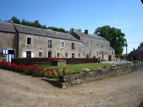 un gran edificio de piedra con flores delante en Cosy Cottage in Barvaux Condroz with Garden, en Barvaux-Condroz