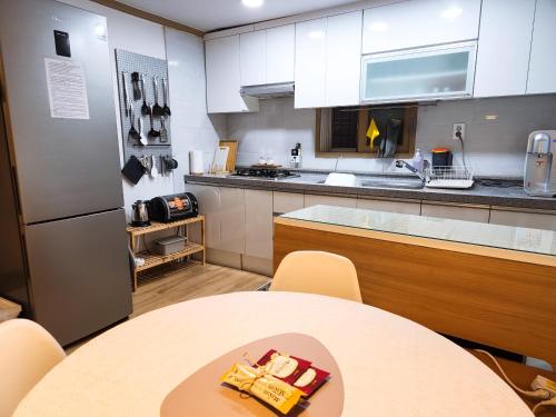 une cuisine avec une table et des placards blancs dans l'établissement 3 Rooms for rent near Mapo-gu Office Station, Mapo-gu, Seoul, à Séoul