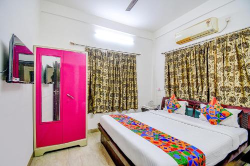 una camera con una porta rosa e un letto di FabExpress Moon Residency a Calcutta
