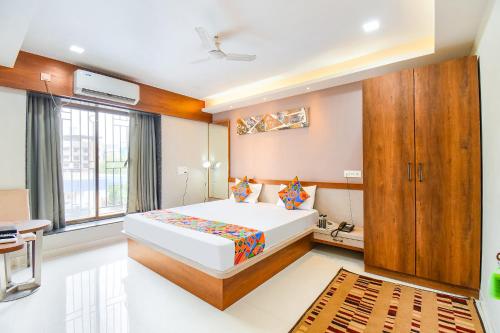 een slaapkamer met een groot bed en een raam bij FabHotel Prime Rajmudra in Pune