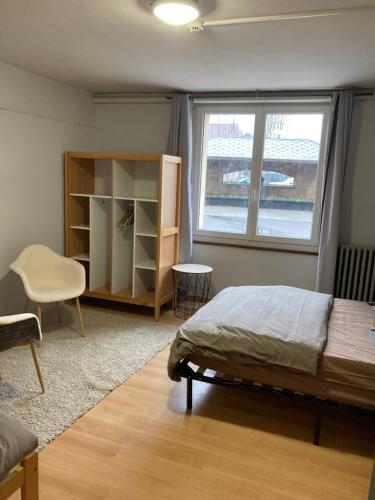 a bedroom with a bed and a window at Chez Hervé le Châtelet in La Chaux Neuve