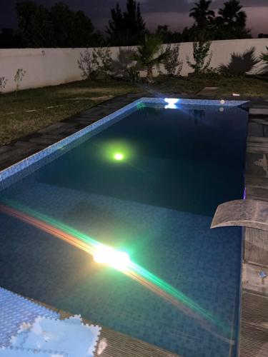 una piscina con luces encendidas por la noche en Maison de fes, en Fez