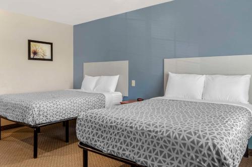 WoodSpring Suites Raleigh Garner في Edmondson: غرفة بسريرين وكرسي