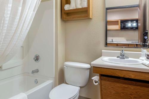 a bathroom with a white toilet and a sink at WoodSpring Suites Raleigh Garner in Edmondson
