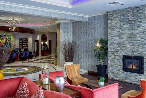 a lobby with red furniture and a fireplace at Viana Hotel and Spa, Trademark Collection by Wyndham in Westbury