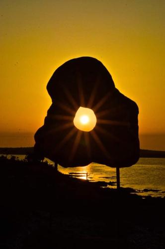 a sunset on the beach with a beach umbrella at Casamia in Portopalo